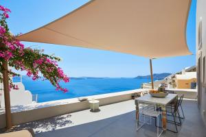 a patio with a table and a view of the ocean at Elegant Santorini House 3 Bedroom Villa Caldera View-Outdoor Hot Tub Oia in Thólos