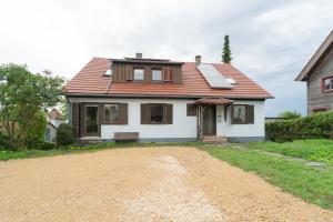 a white house with a red roof and a dirt road at RANGE - Landhaus mit Panoramablick - 2 Apartments - Parkplatz - Küche - WLAN - Monteure 1-11 Personen in Winterbach