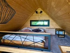 ein Bett in einer Holzhütte mit Fenster in der Unterkunft Greenbela in Banská Belá