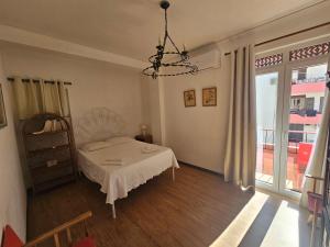 una camera da letto con un letto e un lampadario di Apartamento Sunshine a Monte Gordo