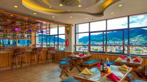a restaurant with tables and chairs and windows at Drishya Hotel in Kathmandu