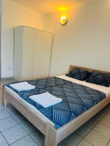 a bedroom with a large bed with blue comforter and pillows at Bright Side Studios in Ljubljana