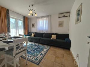 a living room with a couch and a table at E&E Apartments Green Oasis in Igalo