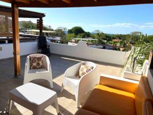 a patio with chairs and a couch on a balcony at Modern Condo with a Rooftop Patio in Coco