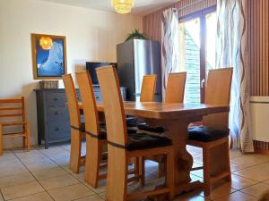 a dining room table with chairs and a refrigerator at Chalet Mitoyen 7p avec Piscine, Sauna, Parking Gratuit et Proche Commerces - FR-1-504-67 in Le Dévoluy