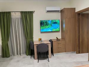 una camera con tavolo e TV a parete di GREENHOUSE maleme ad Ayiá