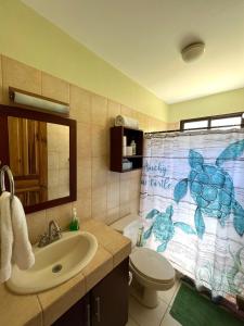 a bathroom with a toilet and a shower curtain at Sea Bottom Ground Condo in Coco