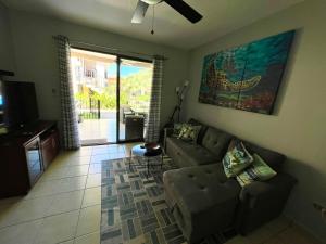 a living room with a couch and a tv at Sea Bottom Ground Condo in Coco