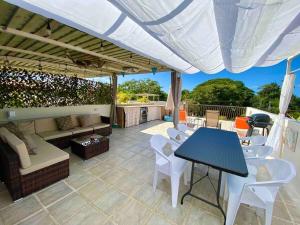 a patio with a table and chairs under a roof at Sun and Waves Getaway in Coco