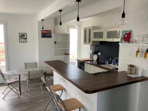 a kitchen with a counter and a table and chairs at Face Mer 2 chambres parking in Hossegor +14 photos