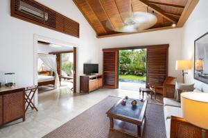 a living room with a couch and a tv at The Residence Zanzibar in Kizimkazi