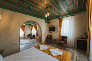 a bedroom with a large bed and a living room at Muse Cappadocia in Uçhisar