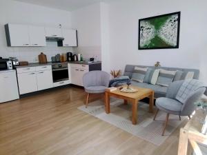 eine Küche und ein Wohnzimmer mit Tisch und Stühlen in der Unterkunft Johnis FeWo, Nähe Stadtzentrum - Uni in sehr ruhiger Lage mit Terrasse und eigenem Parkplatz in Cottbus