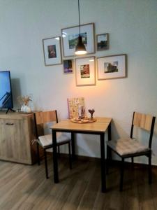 ein Esszimmer mit Tisch, Stühlen und Fernseher in der Unterkunft Johnis FeWo, Nähe Stadtzentrum - Uni in sehr ruhiger Lage mit Terrasse und eigenem Parkplatz in Cottbus