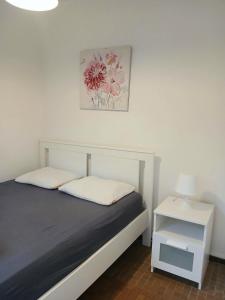 1 dormitorio con cama y mesita de noche blanca en L'Oxymore, en Hastière-par-delà