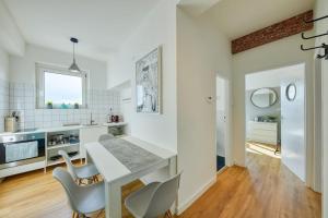 Una cocina blanca con una mesa de comedor y sillas. en Falcon Apartment, Pano, view, Old Town,, en Bratislava