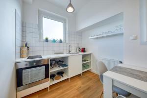 Una cocina blanca con fregadero y estufa. en Falcon Apartment, Pano, view, Old Town,, en Bratislava