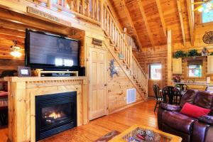 a living room with a fireplace and a flat screen tv at Gorgeous Cabin Hot Tub, Fireplace, Great Location in Sevierville