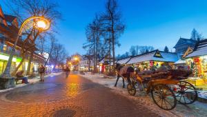 a horse drawn carriage on a city street at night at Krupówki 36 / 8a - Pokój 2 osobowy z widokiem na Giewont in Zakopane +6 photos