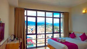 a bedroom with a large window with a view at Drishya Hotel in Kathmandu