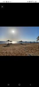 a view of a beach with umbrellas on the sand at شاليه علوى بالروف بقرية فينيسا باجمل شواطئ السخنه in Ain Sokhna