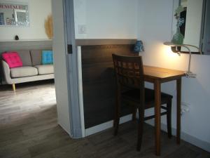 Habitación con mesa, silla y sofá en Logement sur jardin à Fontainebleau, en Fontainebleau