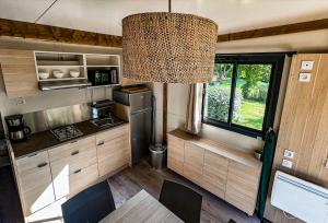 eine Küche in einem Wohnmobil mit einem Tisch und einem Kronleuchter in der Unterkunft Camping Onlycamp Tours Val de Loire in Saint-Avertin
