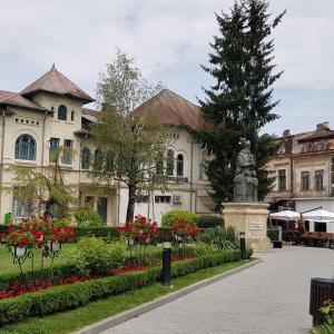 a building with a statue in the middle of a garden at Apartament Centrul Vechi in Târgovişte