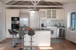 a kitchen with white cabinets and a island with bar stools at PositiveSpace Kalamata Heights in Kalamata