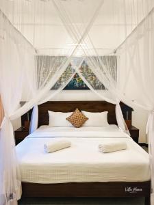 a bedroom with a bed with white drapes at Villa Maria in Bentota