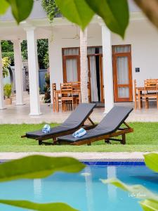 a couple of lounge chairs next to a swimming pool at Villa Maria in Bentota