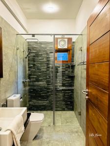 a bathroom with a shower and a toilet and a sink at Villa Maria in Bentota