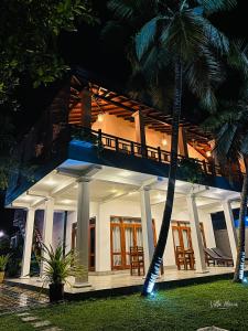a house at night with a palm tree at Villa Maria in Bentota