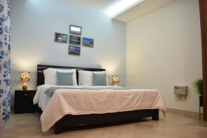 a bedroom with a large bed with blue and white pillows at Two Green Park in New Delhi