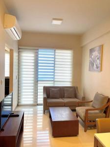 a living room with a couch and a table at The Mactan Newtown Boulevard Studio in Punta Engaño