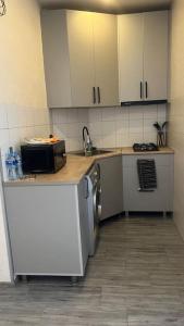 een keuken met witte kasten, een wastafel en een fornuis bij Angisa 72 Sea star in Batoemi