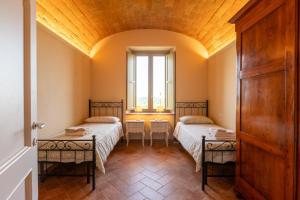 a room with two beds and a window at Sangi Chianti Vacations in Poggibonsi