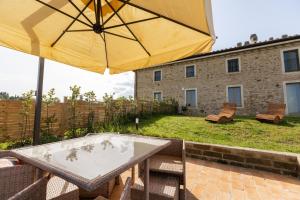 a patio with a table and an umbrella at Sangi Chianti Vacations in Poggibonsi +98 photos