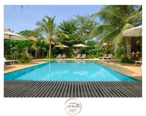 恩加帕鲁La Maison Vanille的配有椅子和遮阳伞的大型游泳池
