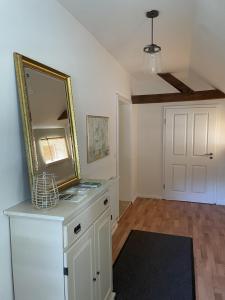 a room with a mirror on a dresser and a door at Twisterhof, appartement Anna, in Sustrum