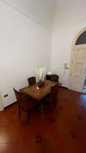 a dining room with a wooden table and chairs at Maison Martina in Bari +5 photos