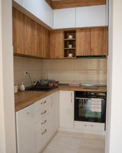 a kitchen with white cabinets and a sink at Apartman Babel in Subotica