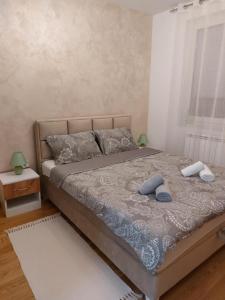 a bed with two pillows on it in a bedroom at Apartman Babel in Subotica