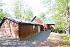 a large wooden building with a garage in the woods at Ahh ... Riverwood in Morton Grove