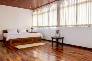 a bedroom with a large bed and a table at Vega Paradise in Kanthalloor