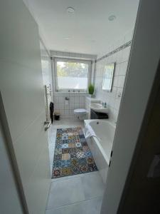 a bathroom with a tub and a toilet and a sink at Apartment - für Monteure und Familien in Salzgitter