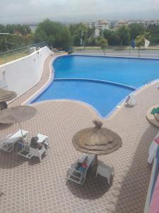 a swimming pool with umbrellas and chairs next to it at Appart-Hotel Cabodream beach in Tétouan +10 photos