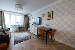 a living room with a table and a television at Apartament Zielona Ochota in Warsaw