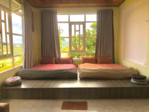 ein Zimmer mit zwei Betten vor einem Fenster in der Unterkunft Pate's Home in Da Lat