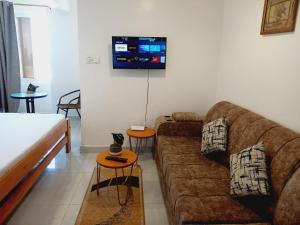Una sala de estar con un sofá y un televisor en una pared. en Studio at Mombasa, Kisimani, Apt 907, en Mombasa